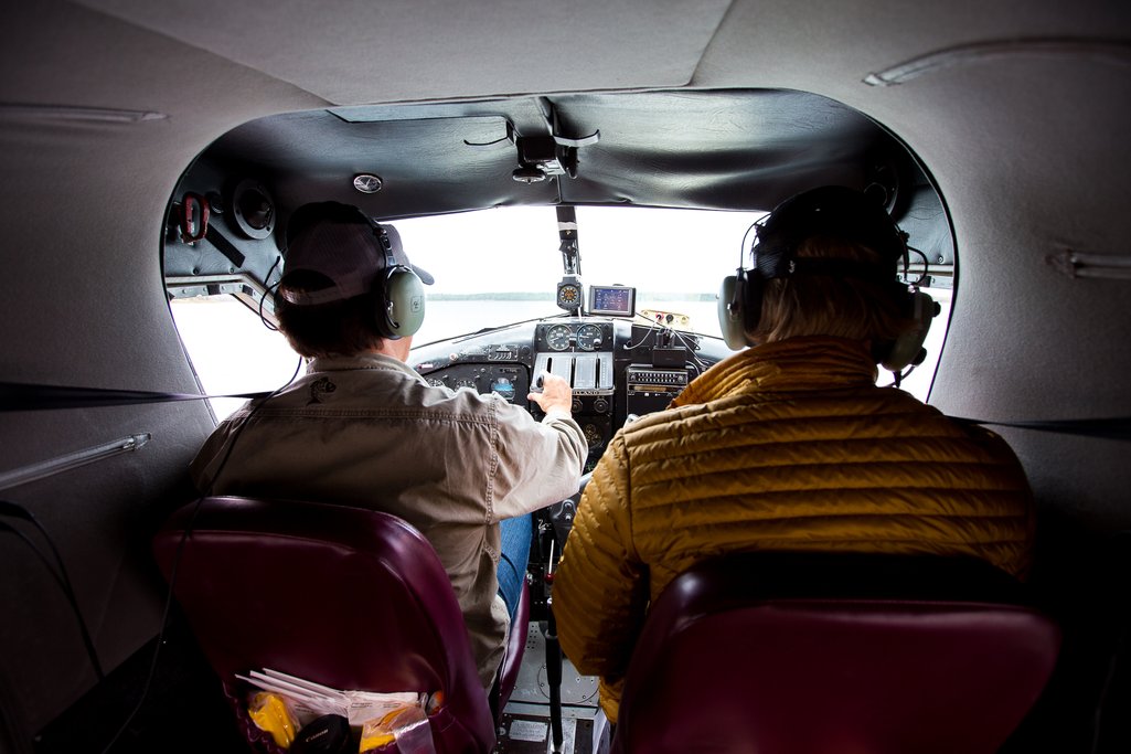 View of cockpit inside small floatplane with pilot and passenger.