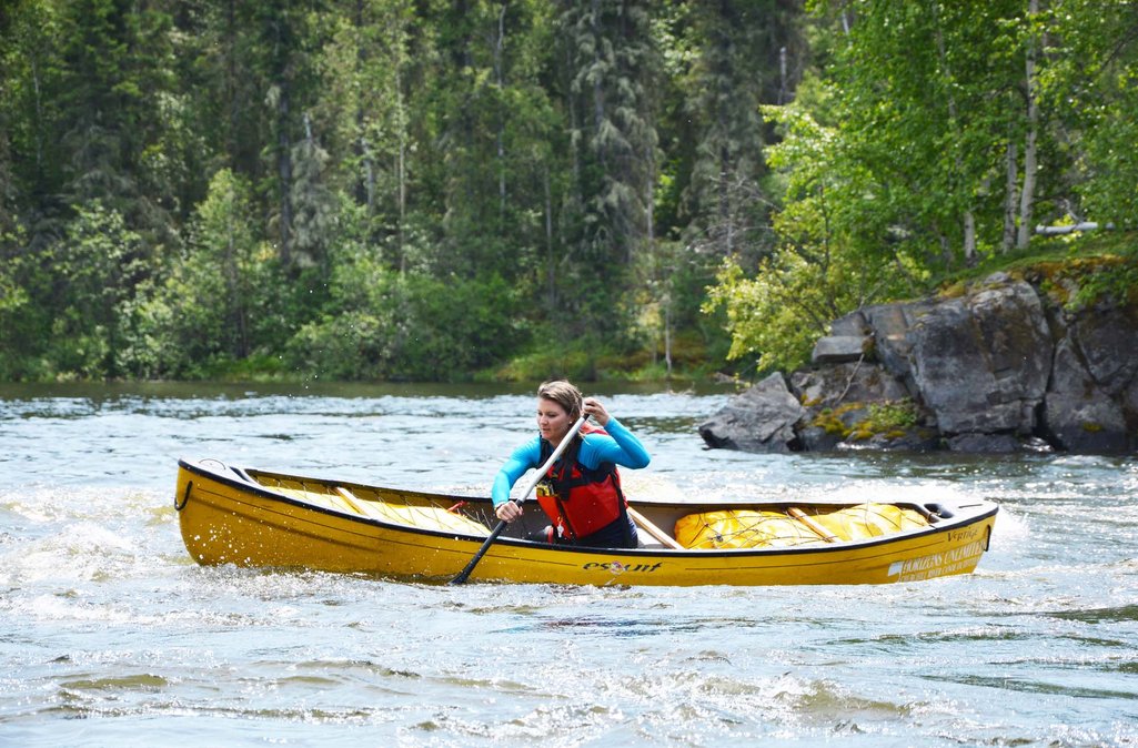 Photo of Ashlyn paddling on the Churchill River in a yellow canoe