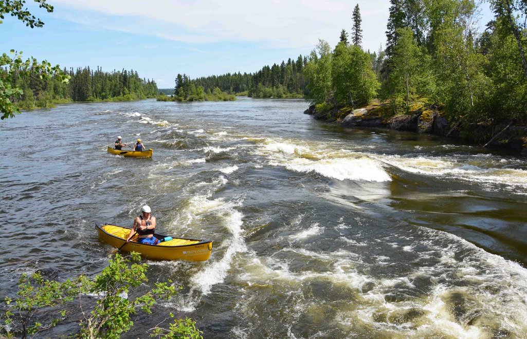 A couple canoes on the Churchill River near a set of small rapids