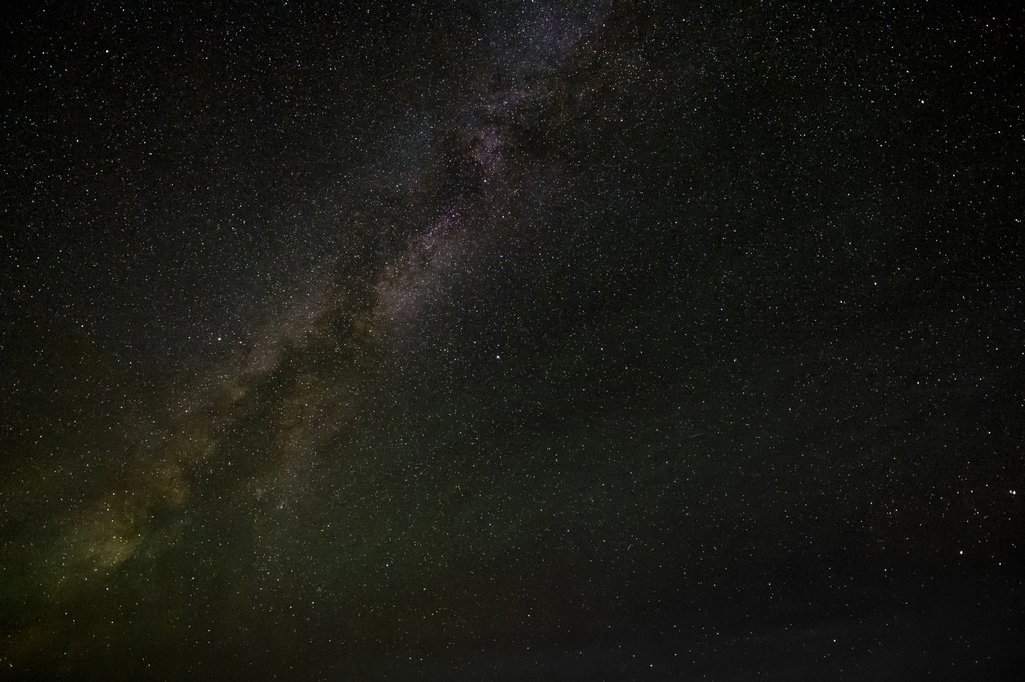 photo of just the starry night sky with the milky way stretching across the left side of the photo