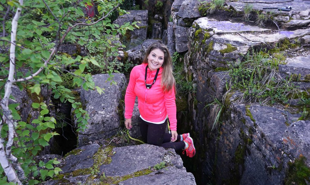 Person smiling at camera after recently climbing out of crevice