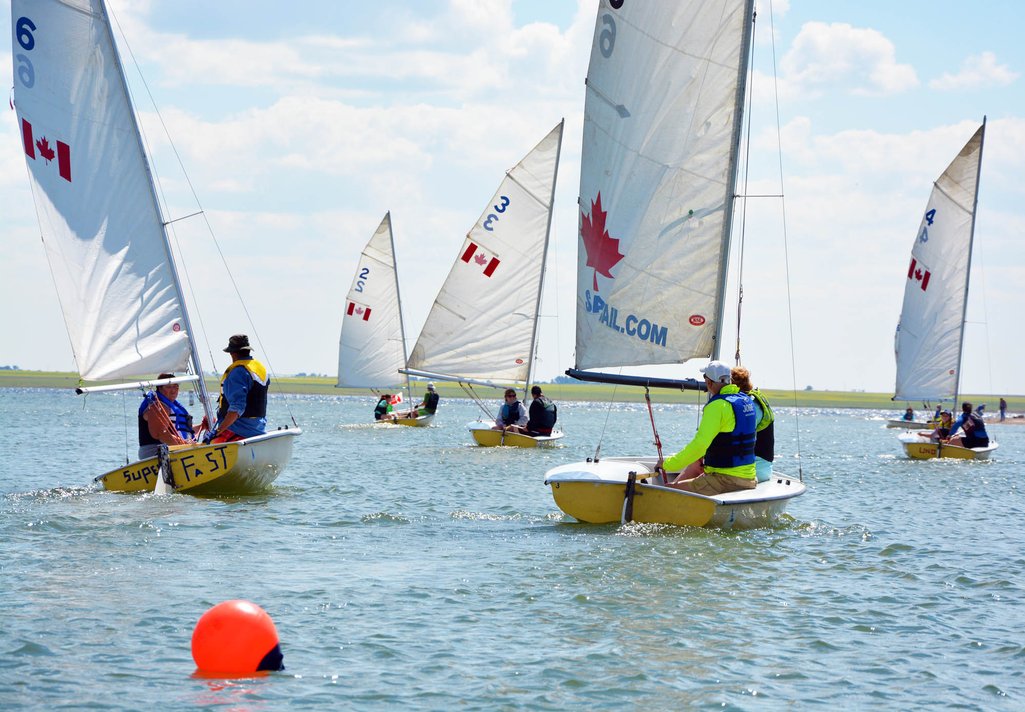 Photo of five sail boats out sailing on Lake Deifenbaker