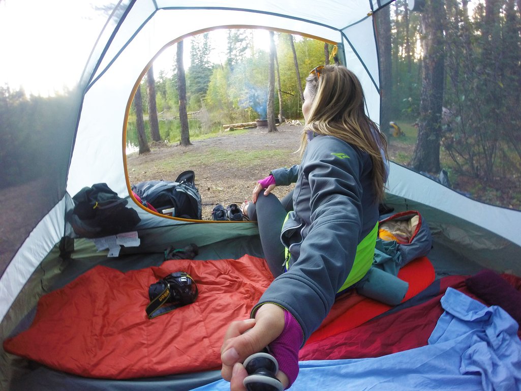 Selfie photo of person inside their tent at a backcountry campsite in Saskatchewan's boreal forest