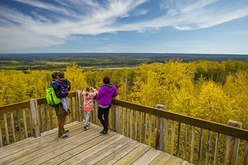 Picture of family on top of wooden tower lookout taking in the view of Prince Albert National Park with autumn colours