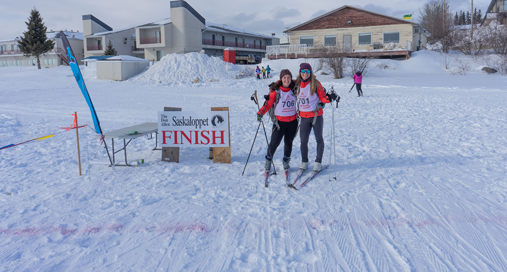 Two skiers celebrating at the finish line of the Don Allen Saskaloppet in La Ronge Saskatchewan