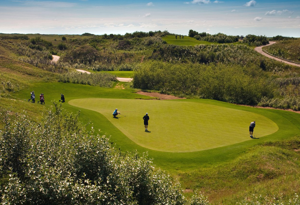 a group of people playing golf putting on a green at Dakota Dunes