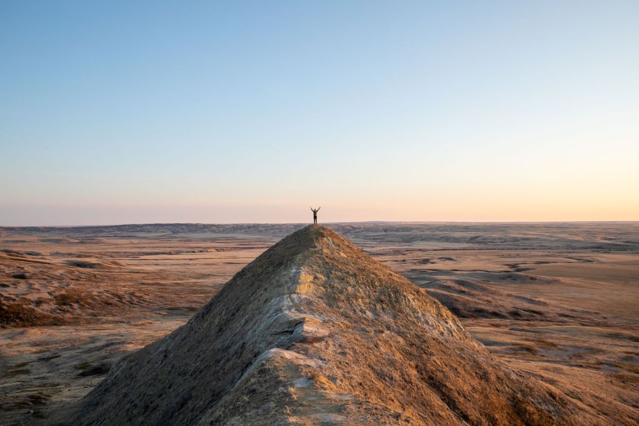 a lone person standing on top of a hill